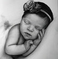 Detailed black and white graphite pencil drawing of a peacefully sleeping newborn baby. The baby is wearing a floral headband and has its tiny hands resting gently against its cheek.