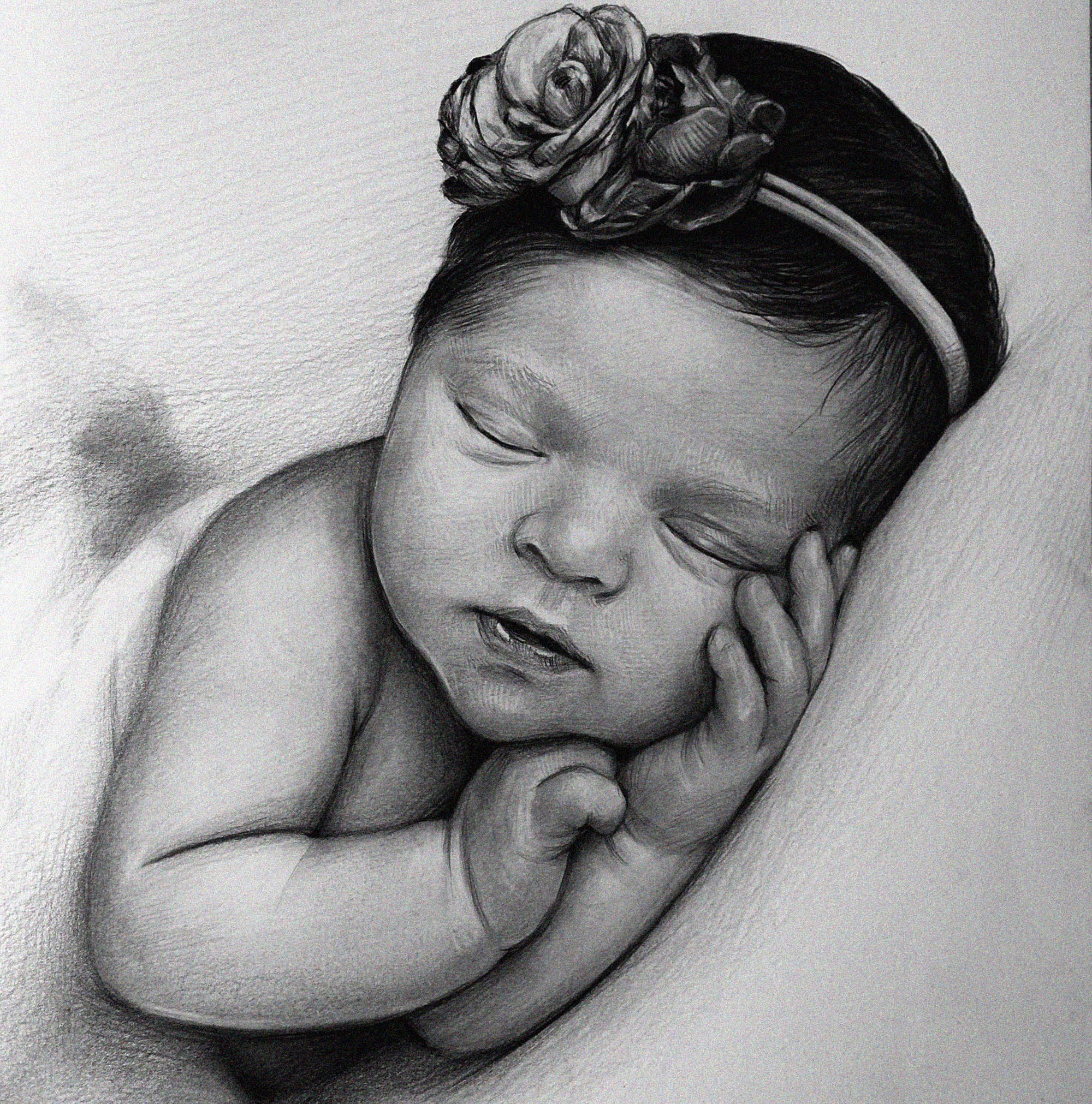 Detailed black and white graphite pencil drawing of a peacefully sleeping newborn baby. The baby is wearing a floral headband and has its tiny hands resting gently against its cheek.