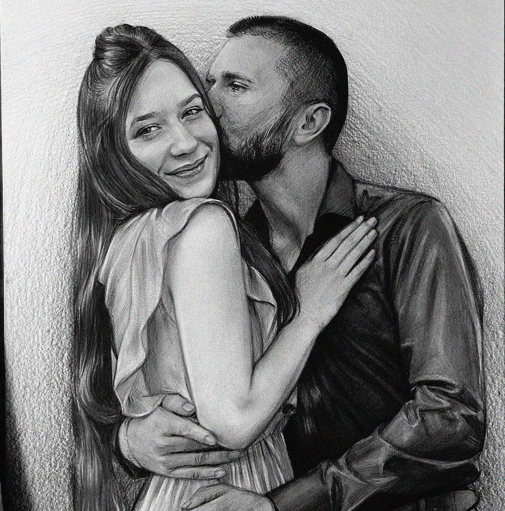 A detailed black and white graphite pencil drawing of a romantic couple embracing. A bearded man in a dark button-down shirt is gently kissing the cheek of a smiling woman. She has long hair tied half-up, is wearing a light-colored dress with ruffled sleeves, and rests her hand on his chest while his arms wrap around her waist.